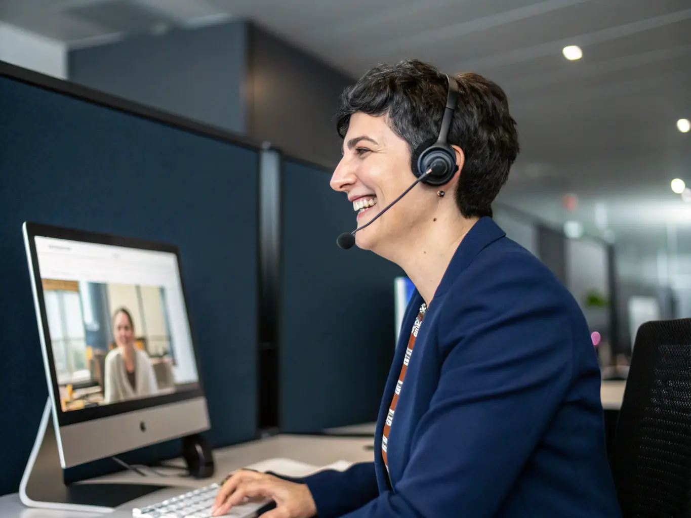 A customer service representative is engaging in a video call with a client, providing personalized support and addressing their inquiries about XMM Technologies' services.